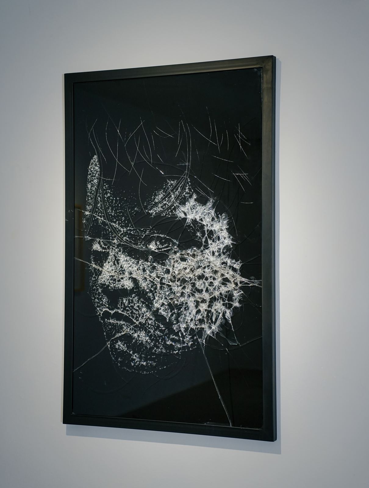 Framed glass fracture portrait under spotlight